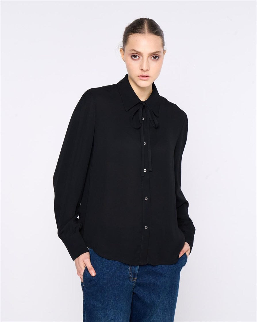 CAMICIA CON DETTAGLIO ANNODABILE AL COLLO. COLLO A PUNTA E MANICHE LUNGHE CON POLSINO. CHIUSURA FRONTALE CON BOTTONI.
